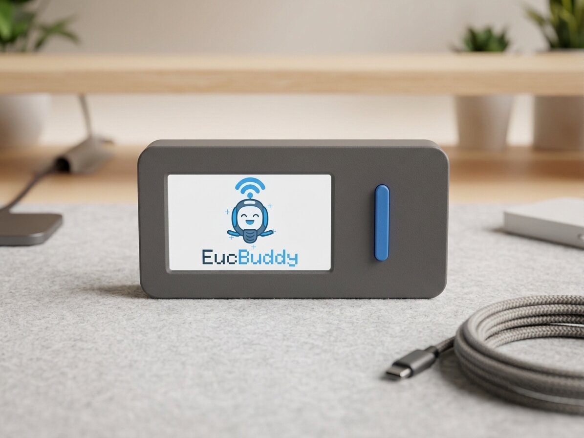 EucBuddy device on a desk, showing the splash screen with the BLE-waved mascot